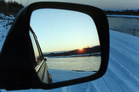 冬の川で、釣りを終えて運転席に座るとミラーの中に夕日が･･･。